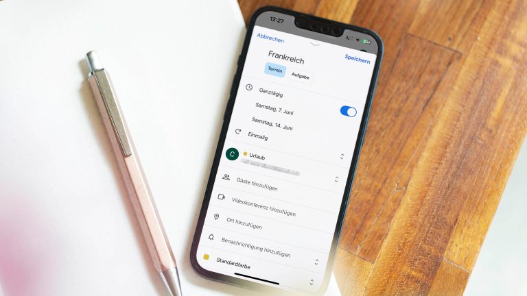 Kalender Apps im Vergleich, So organisierst du deinen Alltag digital Ein iPhone liegt auf einem Schreibtisch. Auf dem Screen ist der Google Kalender geöffnet - ein einmaliger Frankreich-Urlaub wird als Termin festgelegt.