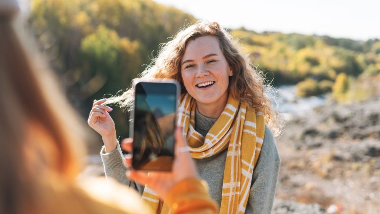 Für den goldenen Herbst, 4 günstige Smartphones mit guter Kamera Eine Person fotografiert eine andere Person in einem herbstlichen Setting.